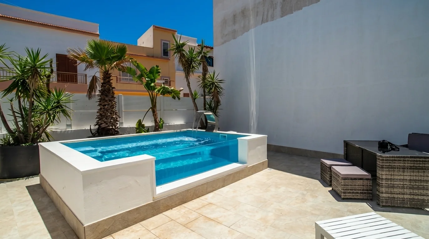 Piscina fuori terra bianca con parete trasparente e cascata