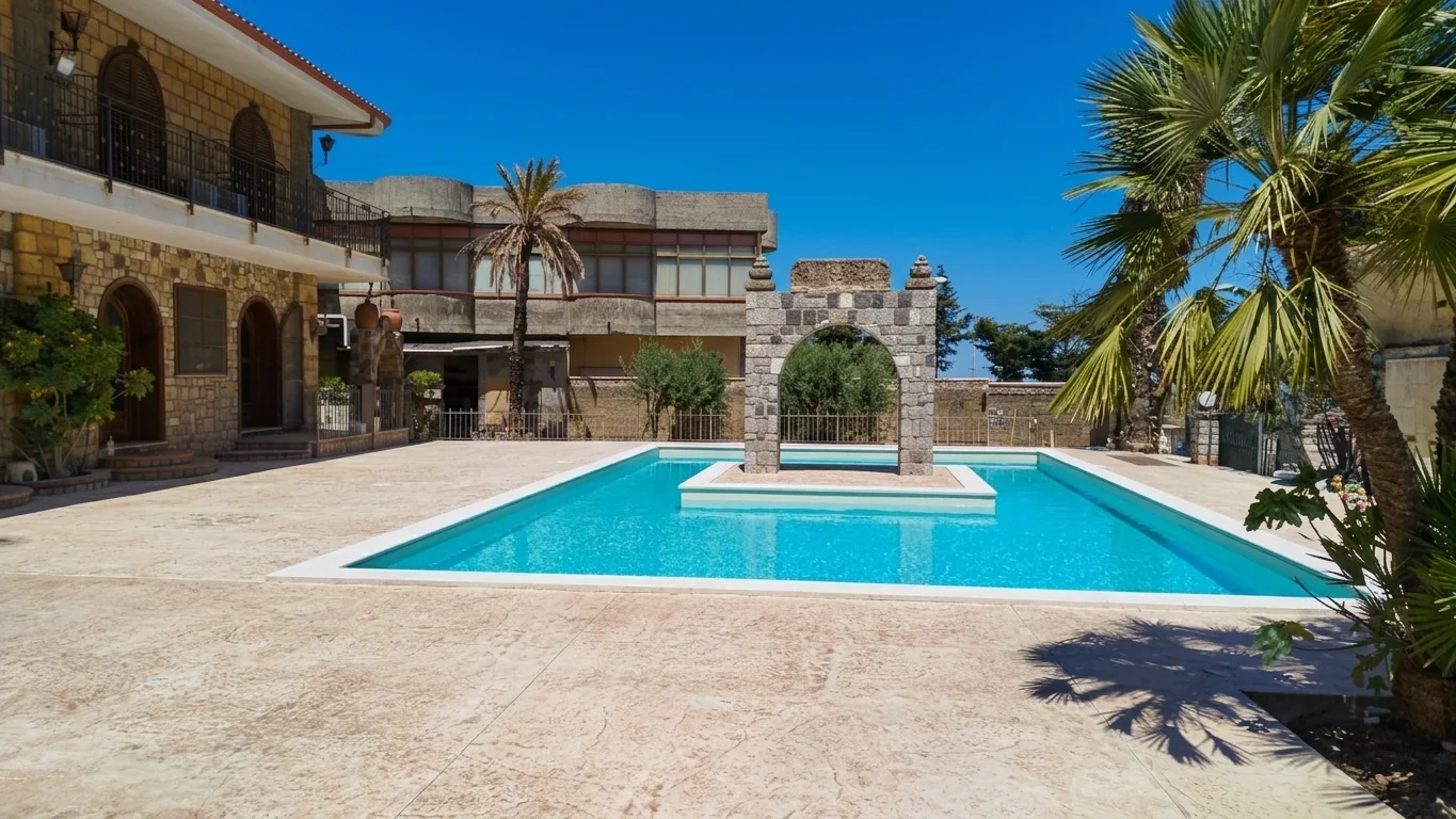 Piscina a skimmer con elemento architettonico centrale in una corte